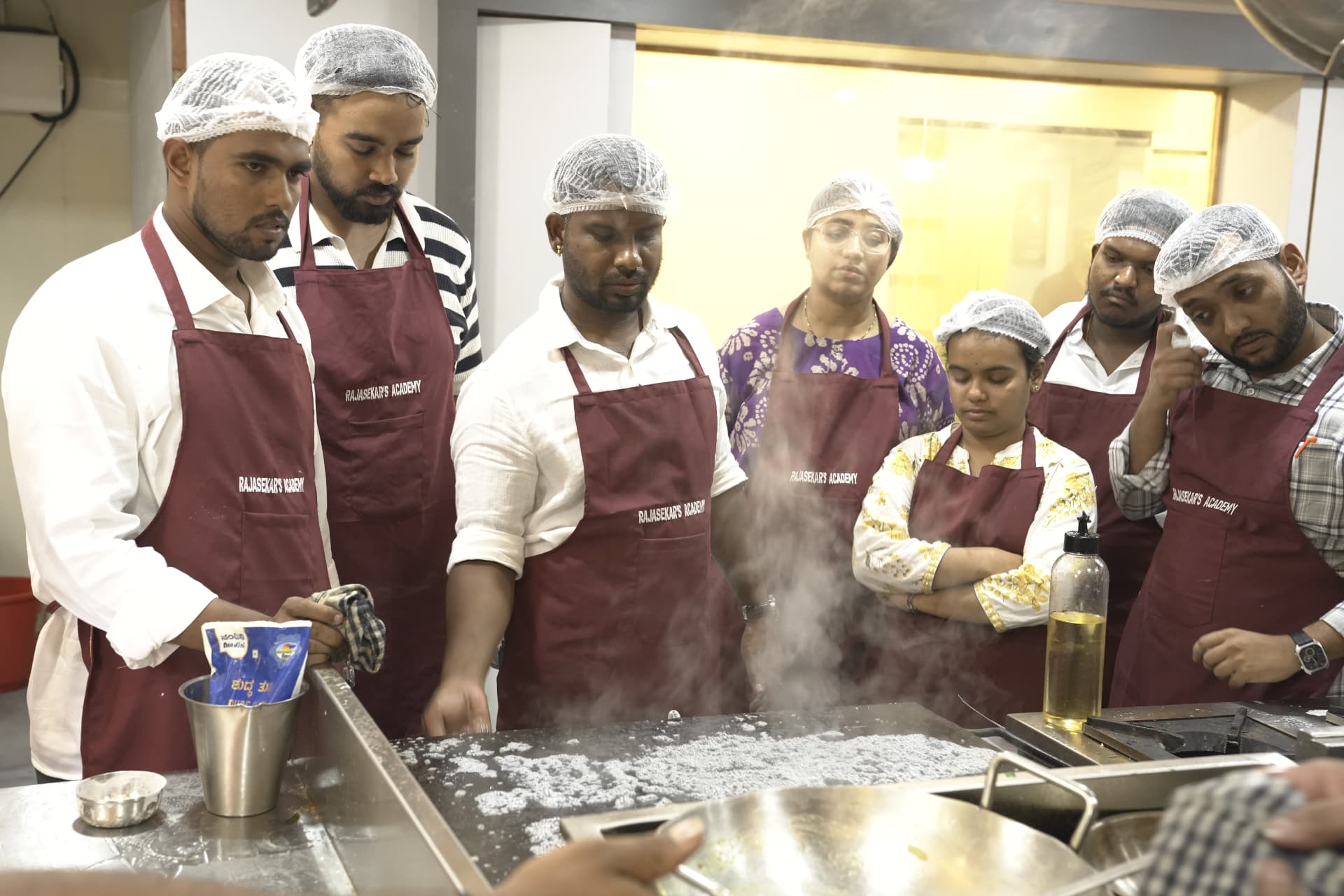 A class gathered around the griddle during a demonstration
